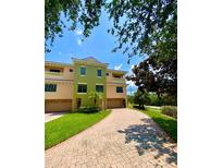 Elegant townhome showcasing a well-manicured lawn and brick driveway leading to a spacious two-car garage at 1503 Citrine Trl, Tarpon Springs, FL 34689