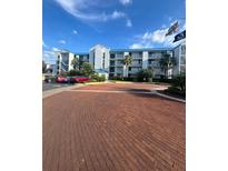 Condo building features a brick entry with parking and patriotic flags waving in the wind at 2424 W Tampa Bay Blvd # 203, Tampa, FL 33607