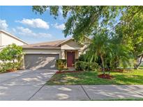 Charming one-story home with a well-maintained yard, beautiful landscaping and two-car garage at 2903 Cypress Bowl Rd, Lutz, FL 33558