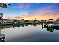 Stunning waterfront view at sunset showcasing docks and boats on tranquil, reflective waters at 3912 Doral Dr, Tampa, FL 33634