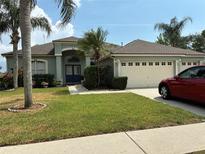Charming single-story home featuring a well-manicured lawn, attached garage, and inviting blue double-door entry at 4512 River Overlook Dr, Valrico, FL 33596