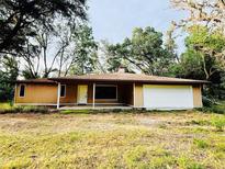 Charming single-story home featuring a well-maintained lawn and an attached garage at 4720 Coats Rd, Zephyrhills, FL 33541