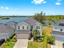 Beautiful two-story home with a well-manicured lawn, professional landscaping, and lovely water views in a Gathering-friendly community at 5040 Inshore Landing Dr, Apollo Beach, FL 33572