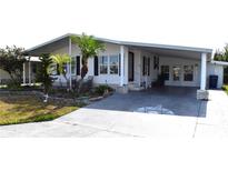 Charming mobile home with a covered carport, landscaped front yard, and delightful curb appeal at 5714 Cheyenne St, Zephyrhills, FL 33542