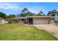 Charming single-story home featuring a well-maintained lawn and a two-car garage at 5905 Berkford Dr, Holiday, FL 34690