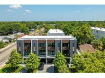 Modern townhome with clean lines, wood accents, landscaped front yard, and a view of lush greenery at 607 W Euclid Ave # 3, Tampa, FL 33602