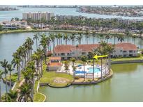 An aerial view of condo community with pool, palm trees, and a lake in the background at 6100 Bahia Del Mar Cir # 105, St Petersburg, FL 33715