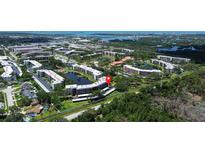 Expansive aerial view of the condo complex with mature trees and serene water features enhancing the community's appeal at 6190 80Th N St # 102, St Petersburg, FL 33709