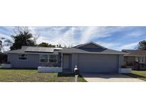 Charming single-story home with an attached garage, solar panels, and well-maintained landscaping at 7524 Oakshire Dr, Port Richey, FL 34668