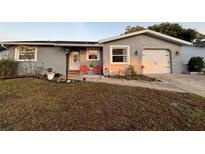 Charming single-story home with a well-manicured lawn, updated paint, and cozy front porch seating at 821 Karen, Palm Harbor, FL 34684