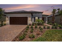 Charming single-story home featuring a brick driveway, two-car garage, and neatly manicured landscaping at 10098 Banyan Breeze Blvd, Land O Lakes, FL 34638