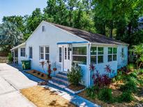 Charming single-story home featuring light blue siding, well-manicured landscaping, and a welcoming entrance at 1221 E Hamilton Ave, Tampa, FL 33604