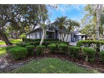 Charming single-story home featuring lush landscaping and a well-maintained lawn on a sunny day at 200 Pinewinds Blvd, Oldsmar, FL 34677