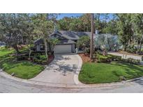 Charming single-story home featuring a well-manicured lawn, mature landscaping, and an attached two-car garage at 200 Pinewinds Blvd, Oldsmar, FL 34677