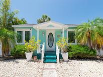 Charming cottage-style home features a quaint front porch, colorful exterior, and inviting landscaping at 3031 56Th S St, Gulfport, FL 33707