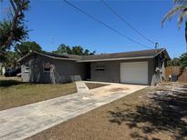 Charming single-story home featuring a one-car garage, gray brick exterior, and a well-manicured lawn at 5813 Oxford Dr, Tampa, FL 33615