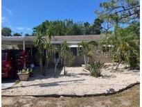 Charming single-story home with a carport and mature landscaping at 7425 W Maryland W Ave, Hudson, FL 34667