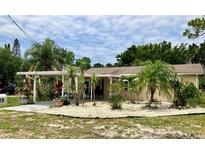 Charming single-story home featuring lush landscaping, rock garden, and a convenient carport at 7425 W Maryland W Ave, Hudson, FL 34667