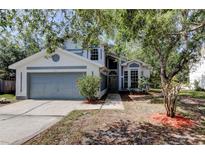 Charming two-story home featuring a well-maintained front yard, attached garage and inviting facade at 8110 Pond Shadow Ln, Tampa, FL 33635