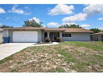 Charming single story home with an attached garage, neutral color, and walkway to front door at 10435 Tassel St, Spring Hill, FL 34608