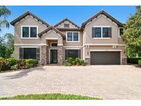 Stately home with a three-car garage, beautiful landscaping and a paver driveway, exuding curb appeal at 11624 Calf Path Dr, Tampa, FL 33626