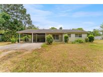 Charming single-story home featuring a carport, green landscaping, and a well-maintained lawn at 1609 S Valrico Rd, Valrico, FL 33594