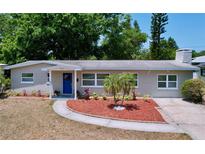 Charming single-story home with a blue front door, fresh landscaping, and a well-manicured lawn at 2152 74Th N St, St Petersburg, FL 33710