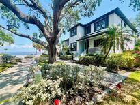 Charming two-story home featuring lush landscaping, a well-manicured lawn, and a view of the sea at 2802 Northpointe Ln, Tampa, FL 33611