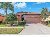 Charming single-story home featuring a well-manicured lawn, mature landscaping, and a two-car garage at 310 Cedar Falls Dr, Apollo Beach, FL 33572