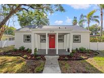 Charming home featuring a bright red front door and well-maintained landscaping at 5724 Dr Martin Luther King Jr N St, St Petersburg, FL 33703
