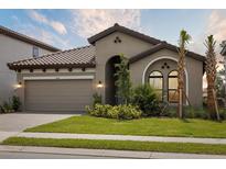 Beautiful single-Gathering home featuring a well-manicured lawn and classic architectural details under a blue sky at 8514 Dove Bog Ter, Parrish, FL 34219