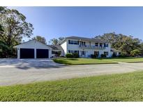 Beautiful two-story home featuring a two-car garage, balcony, and well-manicured lawn at 1089 Virginia St, Dunedin, FL 34698