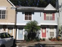 Street view of townhomes showcasing colorful exteriors and landscaping at 11327 Regal Square Dr, Temple Terrace, FL 33617