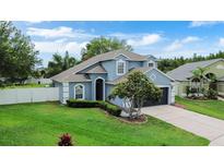 Charming two-story home features lush lawn, mature trees, and meticulous landscaping at 1948 Grenville Ct, Wesley Chapel, FL 33543