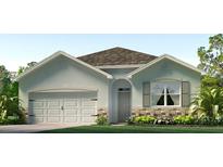 Charming single-story home with a two-car garage, stone accents, and professionally landscaped front yard at 3327 Thistle Bank Ct, Plant City, FL 33565