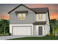 Charming two-story home featuring a two-car garage, gray siding, and a well-manicured lawn at 4210 Goldfoil Rd, Spring Hill, FL 34609