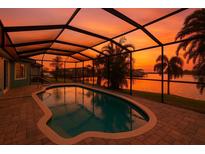 Enclosed pool featuring a stunning sunset view over the water at 6530 Manila Palm Way, Apollo Beach, FL 33572