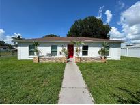 Charming single-story home features a vibrant red door and stone accents, enhancing its curb appeal at 7102 Reindeer Rd, Tampa, FL 33619