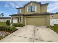 Two-story home featuring a two-car garage, neutral color scheme, and manicured landscaping for enhanced curb appeal at 8452 Silverbell Loop, Brooksville, FL 34613