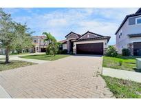 Charming home featuring a tile roof, well-manicured lawn, and a paved driveway leading to a two-car garage at 12055 Cardinal Flower Dr, Riverview, FL 33579