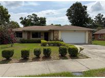 Charming single-story home features a well-maintained lawn, mature landscaping, and an attached two-car garage at 13742 14Th St, Dade City, FL 33525