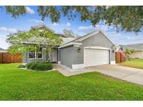 Charming single-Gathering home featuring a two-car garage, well-manicured lawn, and beautiful landscaping at 2667 Aspen Ct, Palm Harbor, FL 34684