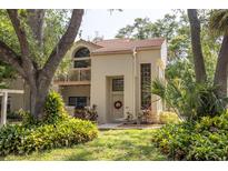 Inviting two-story home featuring a balcony, tile roof, and lush landscaping at 307 Los Prados Dr # 307, Safety Harbor, FL 34695