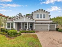 Beautiful two-story home with manicured lawn, brick-paved driveway, and three-car garage at 3326 Barbour Trl, Odessa, FL 33556