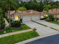 Inviting home featuring a tile roof, lush landscaping, and a multi-car garage, creating great curb appeal at 3762 Darston St, Palm Harbor, FL 34685