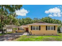 Charming single-story home featuring a carport, well-maintained lawn, and traditional architectural details at 39542 Friends Ave, Zephyrhills, FL 33540