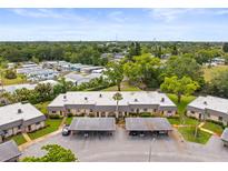 Low angle shot of a multi-unit residential building with attached covered parking and well-maintained landscaping at 4305 Summersun Dr, New Port Richey, FL 34652