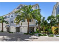 Charming townhome with tropical landscaping, colorful exterior, and a convenient one-car garage, perfect for coastal living at 6140 Marina Cove S Way, St Petersburg, FL 33712