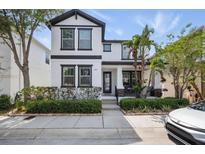 Charming two-story home with manicured landscaping and a welcoming front porch, and attractive black and white design at 7307 S Trask St, Tampa, FL 33616