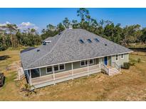 Charming single-story home with a spacious wraparound porch and a well-maintained yard at 8755 Ogleby Creek Rd, Myakka City, FL 34251
